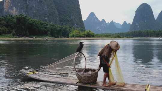 桂林漓江渔民在山水间撑竹筏撒网捕鱼的场景