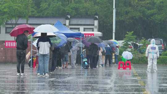 暴雨中排队核酸检测的市民