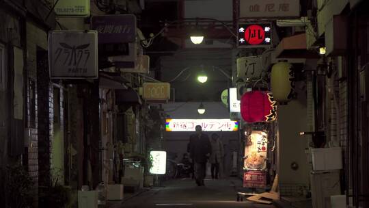 人们走在黑暗的东京小巷