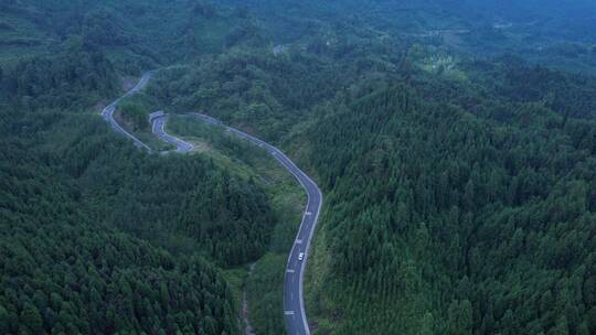 山峦叠嶂山林盘山公路俯瞰行车白色车辆