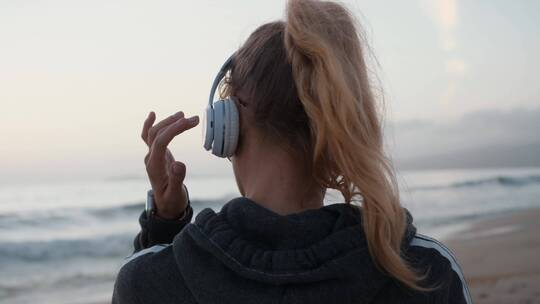 女孩吹着海风听着音乐