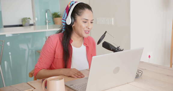 录制播客，亚洲女人使用笔记本电脑和麦克风