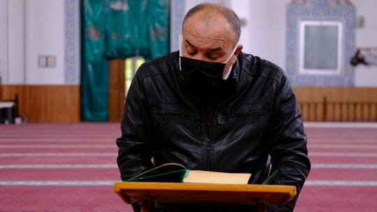 斋月期间老人戴着口罩阅读古兰经视频素材模板下载
