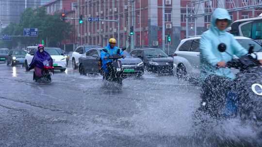 雨天男子骑电动车过路口