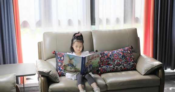 小女孩坐在沙发上看书