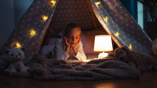 女孩趴在帐篷里看书视频素材模板下载