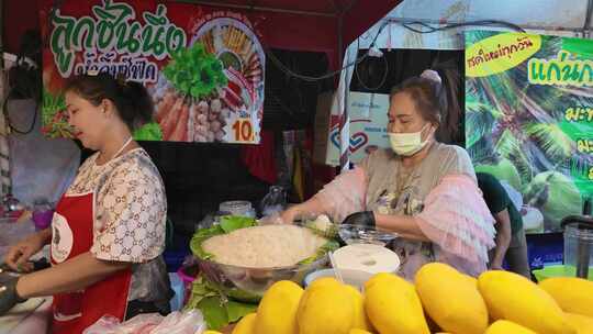 泰国清迈夜市摊位上的女性在准备食材