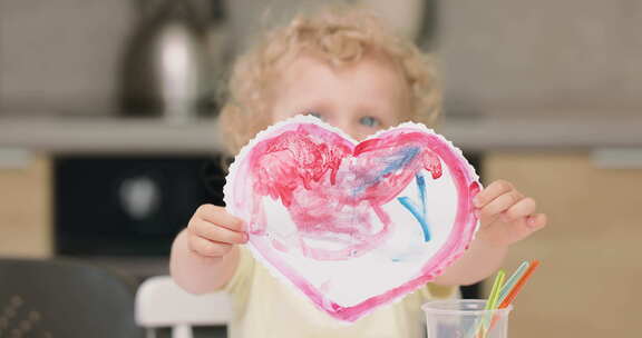 水彩画小女孩切割和绘制的一颗红心的特写镜头