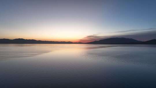 清晨朝霞倒映在赛里木湖平静的湖面航拍