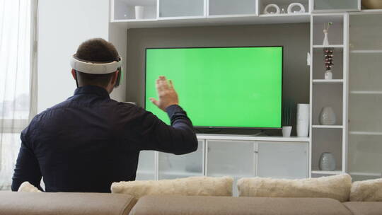 男人带着虚拟现实眼镜看着绿屏