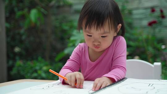 可爱的亚洲小女孩在院子里画画