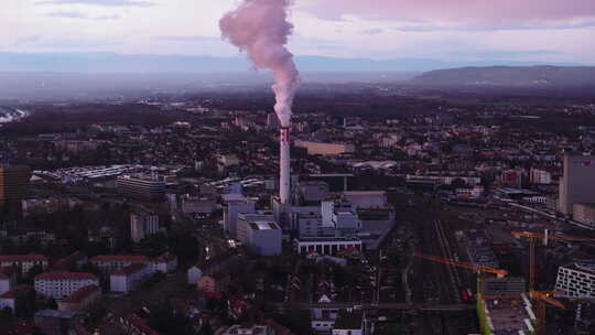 城市郊区工厂或供热厂烟囱大量冒烟的空中滑视频素材模板下载