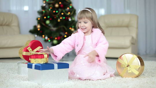 可爱的女孩在圣诞树旁拆礼物