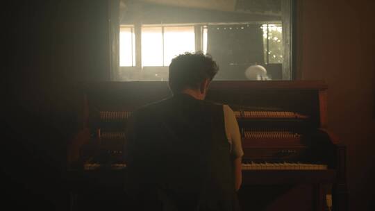 一个在弹钢琴男人的背影视频素材模板下载