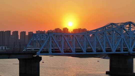 中国高铁和谐号复兴号动车黄昏穿过桥梁