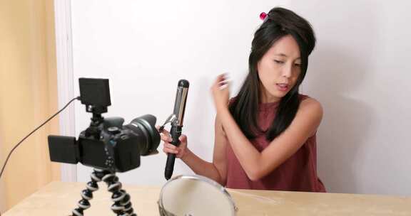 女人在家为美容产品拍摄视频