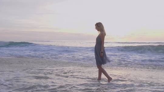 美丽的女人行走在海边
