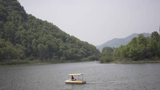 群山围绕中人在湖面上划船