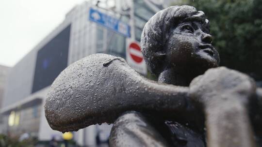上海南京路下雨天雕像在雨中孤单铜像