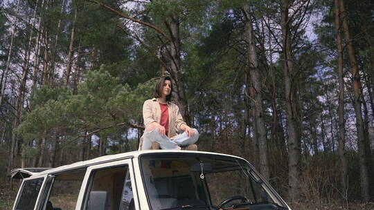 森林里女人坐在车顶上打坐