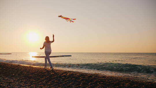 女人沿着海滩放风筝视频素材模板下载