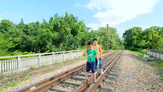 小孩走在铁路上玩耍