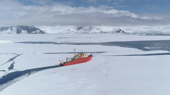 南极水域航行的红色破冰船空中缩放视图
