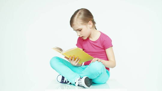 女孩盘腿坐在地上读书