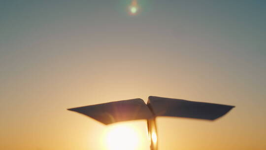 一架纸飞机在天空中飞行迎接落日