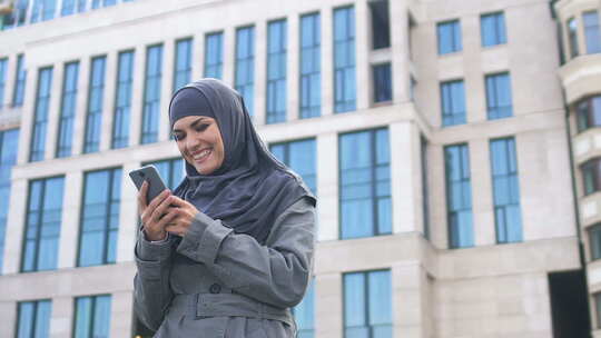 穆斯林女孩在电话上读到好消息后表现出是的手势，成功的职业生涯