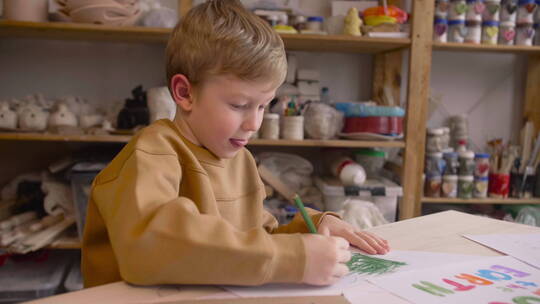 小男孩在桌子前画画
