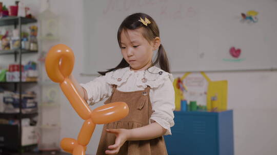 小女孩在玩狗形状的长气球