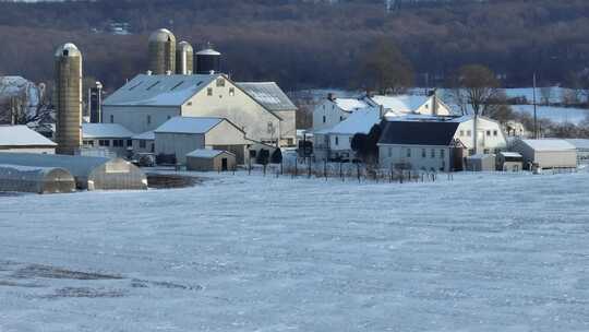 被雪覆盖的阿米什农场。空中升起的镜头揭示