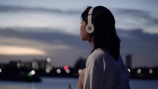 傍晚女孩在江边戴着耳机听歌4k视频素材视频素材模板下载