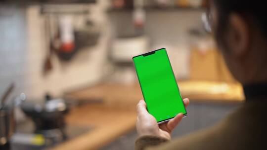 中年女性室内使用绿色屏幕抠像替换绿幕手机