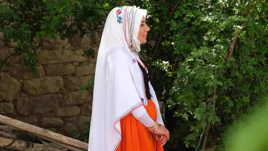 身着传统服装的年轻女子在村里与朋友交谈