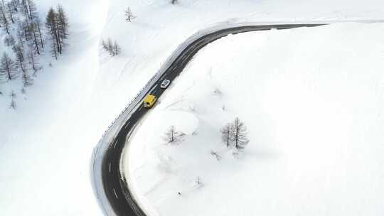 航拍汽车行驶在雪后的公路上