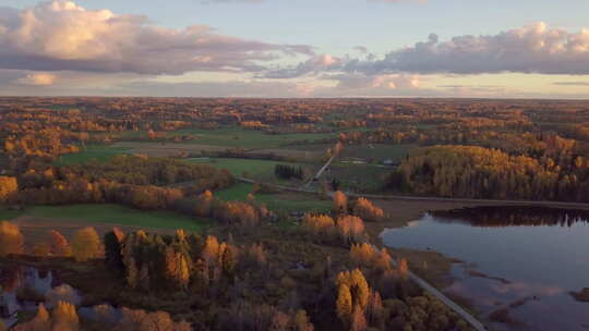 在多彩的秋季日落中，田野、森林和池塘与乡村自然的航拍-SLOWLY PA