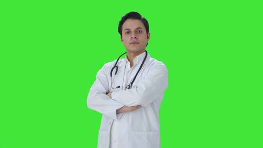 自信的印度医生双手交叉站立的肖像绿屏