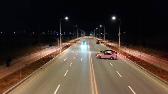 夜晚公路上一排跑车在行驶