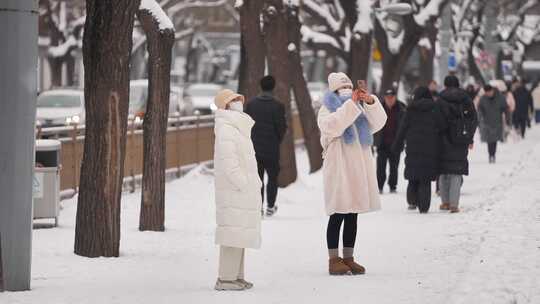 街头行人雪中拍照场景