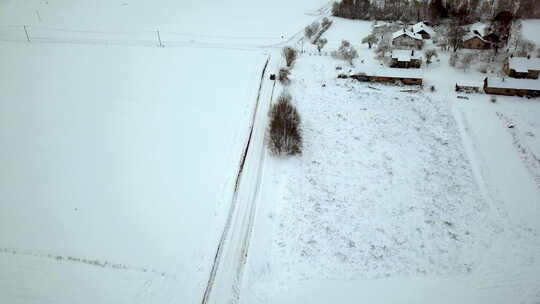 缓慢的空中跟踪拍摄汽车行驶并到达冰冻和积雪覆盖的农村十字路口视频素材模板下载