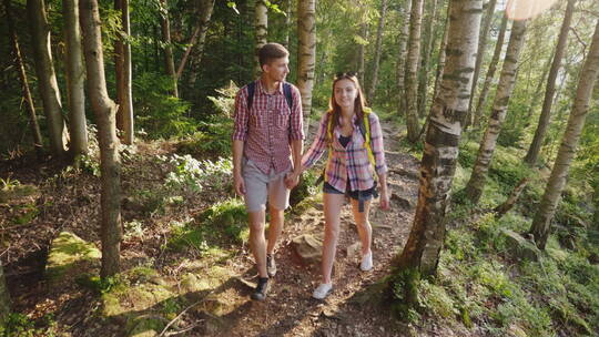 年轻游客沿着森林中的小径行走