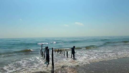 海浪冲击站在海边的人视频素材模板下载