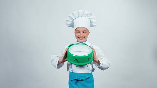 穿着厨师服的孩子拿着闹钟欢笑