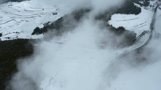 冬季雪景云雾下积雪覆盖梯田公路树林