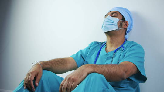 疲惫的中年外科医生摘下口罩大口呼吸视频素材模板下载