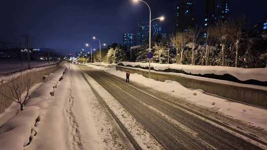 一个人独自在积雪的道路上行走