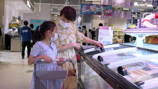 疫情期间戴口罩在商场超市采购商品的母女