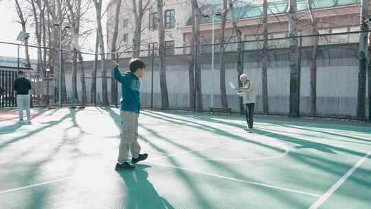 老人和孩子打羽毛球